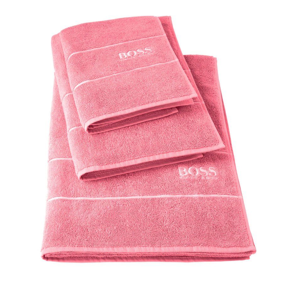 Trois serviettes roses sont empilées les unes sur les autres