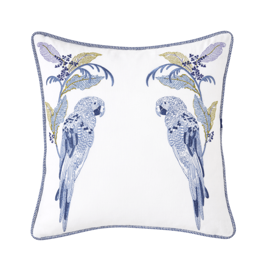 Un oreiller blanc avec deux perroquets bleus dessus