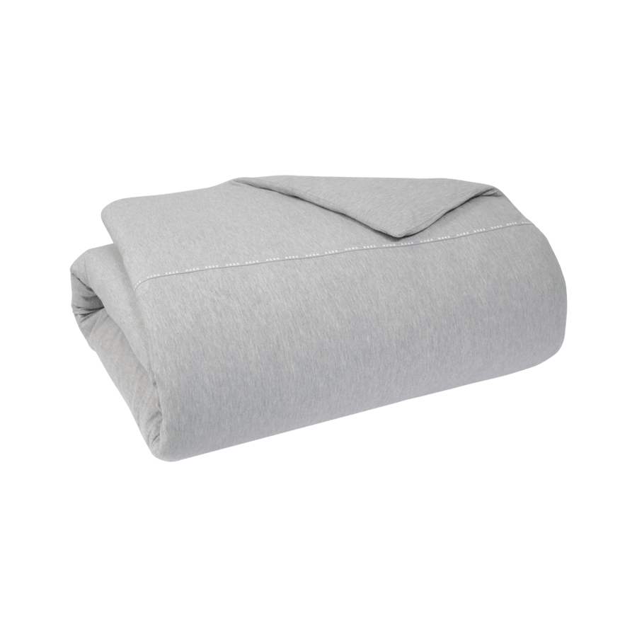 Une couverture grise est enroulée sur un fond blanc