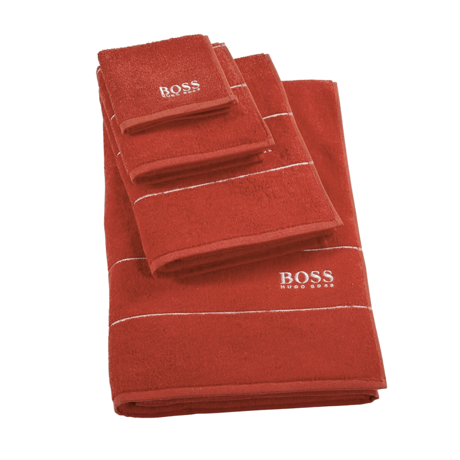 Une pile de serviettes de bain rouges sur fond blanc