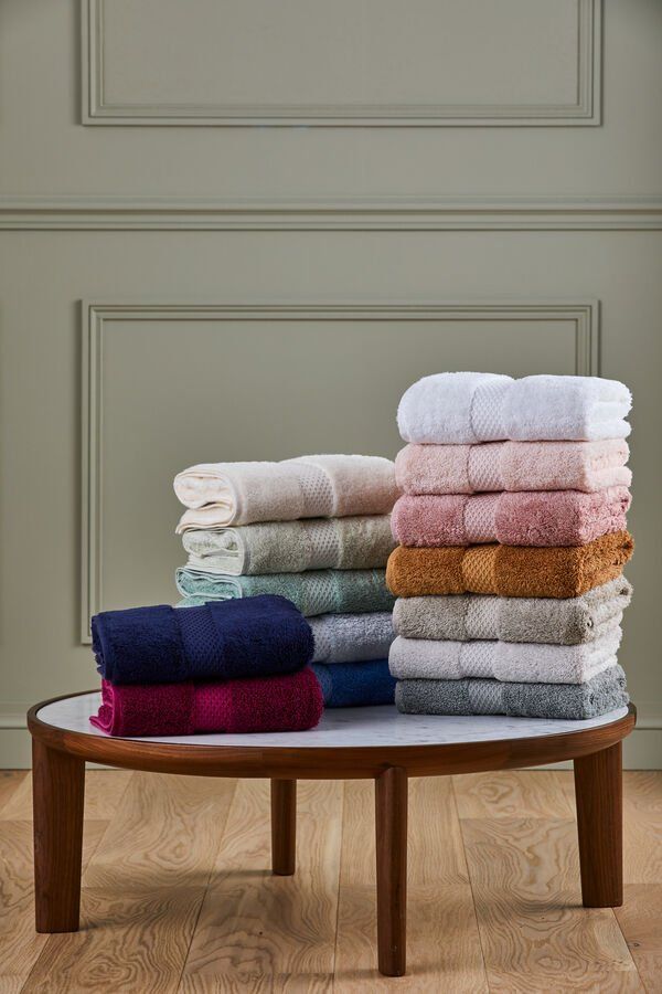 Une table surmontée de piles de serviettes de différentes couleurs.