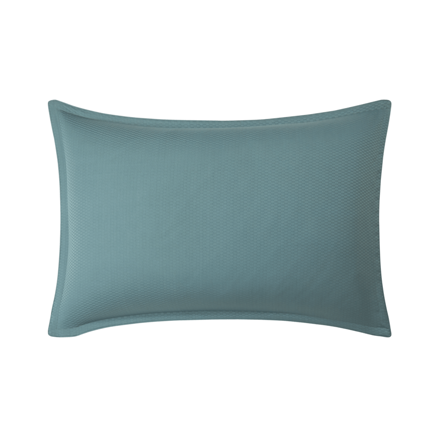 Un oreiller bleu est posé sur une surface blanche.