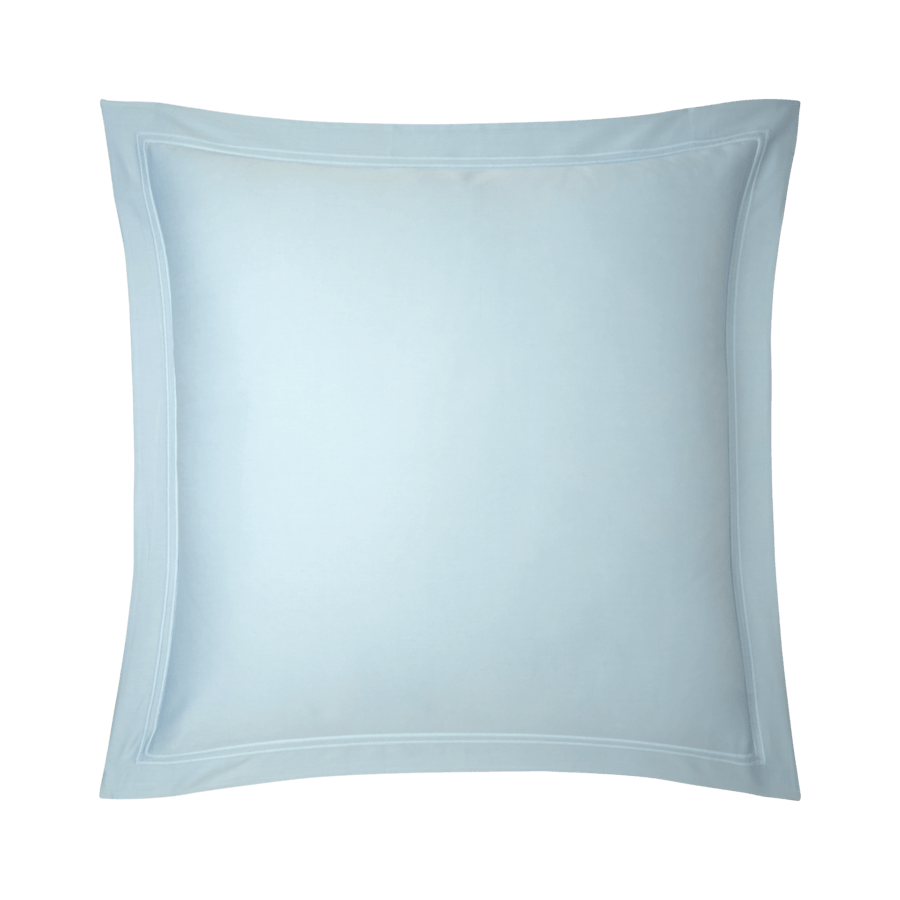 Un coussin bleu clair avec une bordure blanche sur fond blanc.