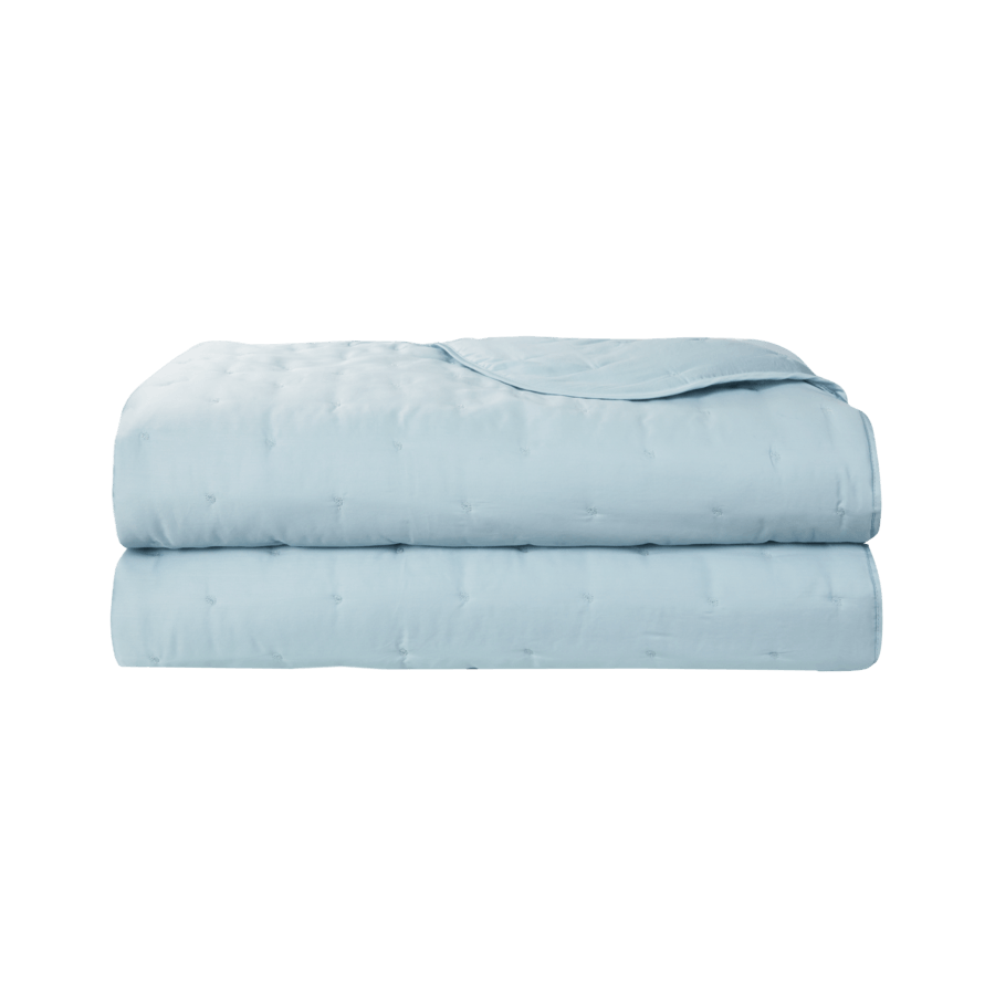 Deux couvertures bleu clair sont empilées l'une sur l'autre sur un fond blanc.