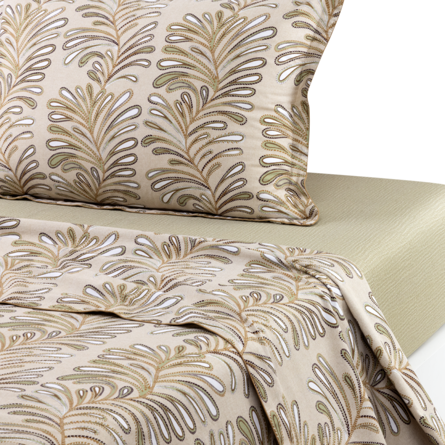 Ensemble de literie avec un motif de feuilles de fougère beige, blanc et marron sur un oreiller et un drap-housse assorti plié sur une surface texturée.