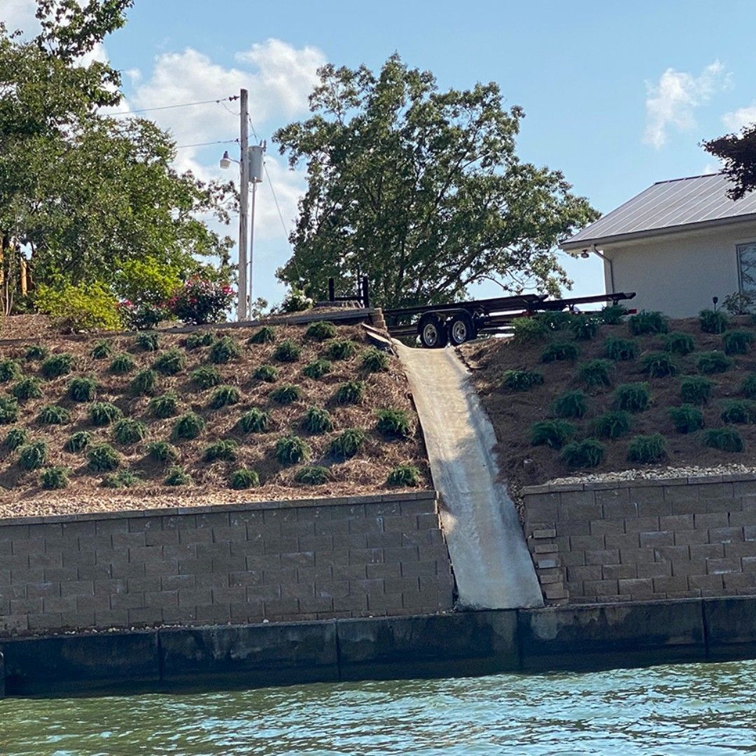 A truck is driving down a hill next to a body of water.