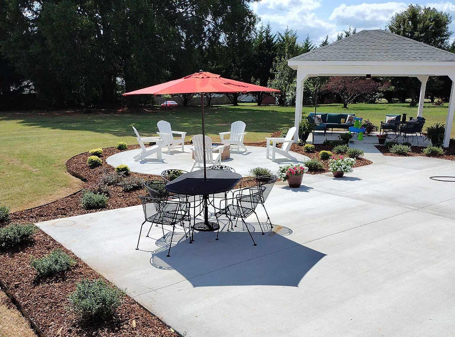 A patio with a table and chairs and an umbrella