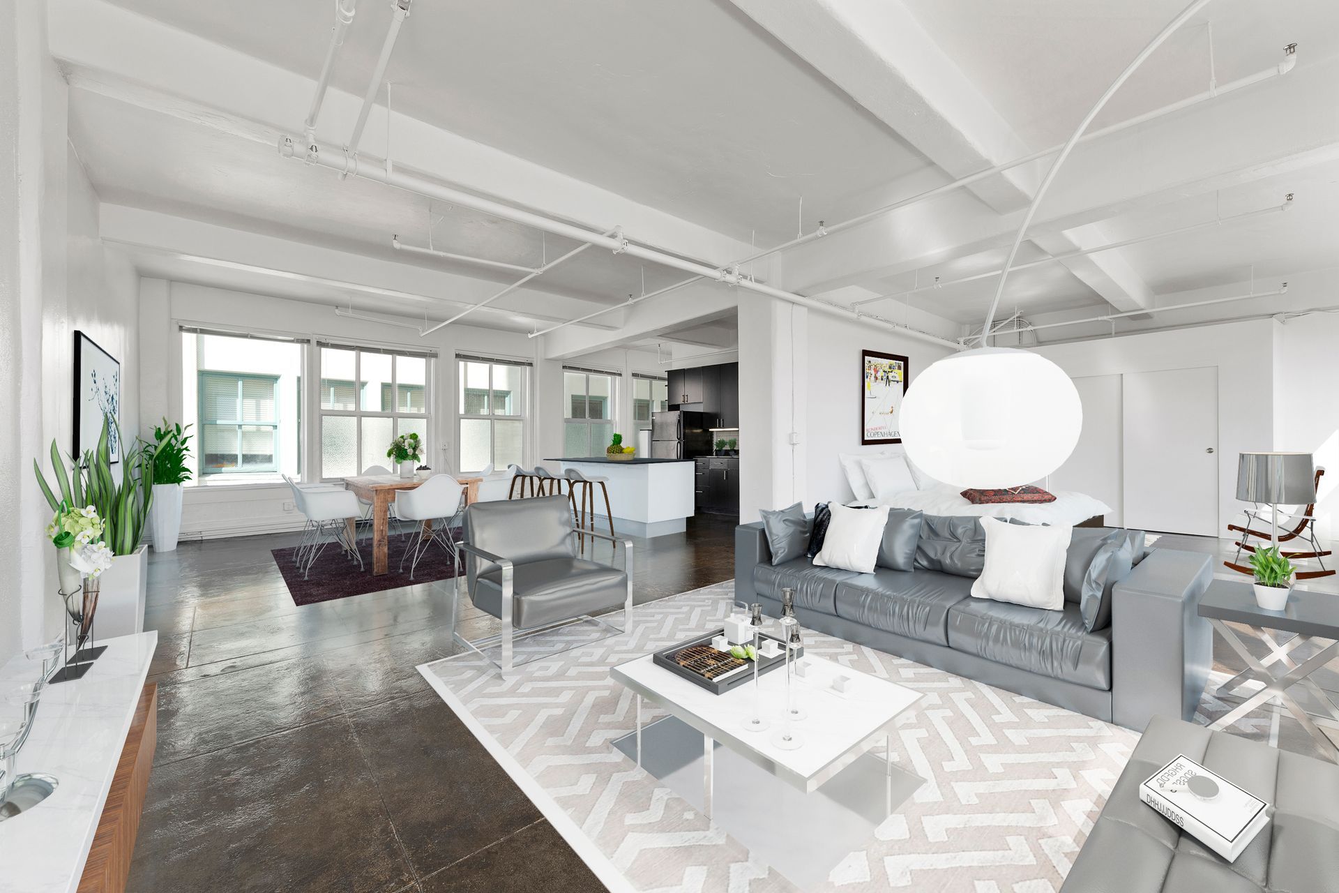 Bright modern open-plan living room with gray sofa, white rug, dining area, and large windows