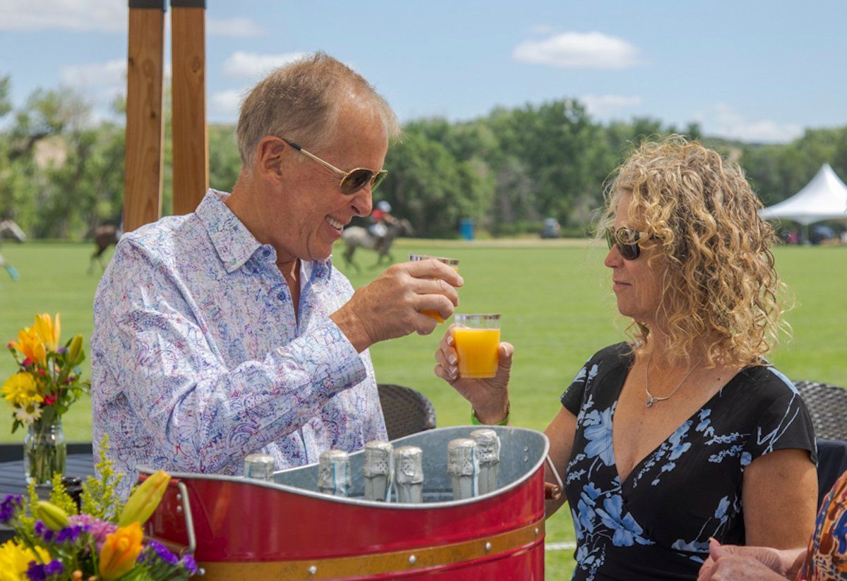 A man and a woman are drinking orange juice in a cooler.