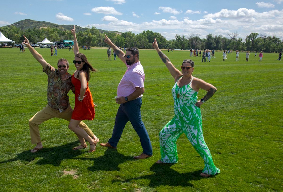 A group of people are posing for a picture in a grassy field.