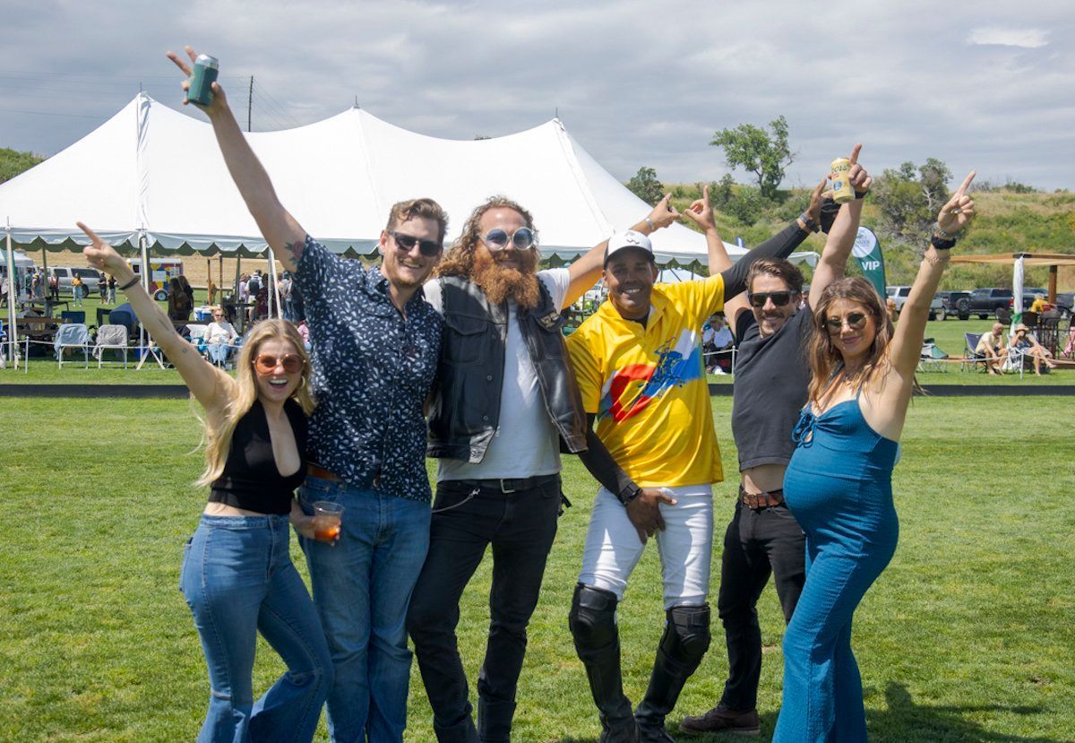 A group of people are posing for a picture in a field.