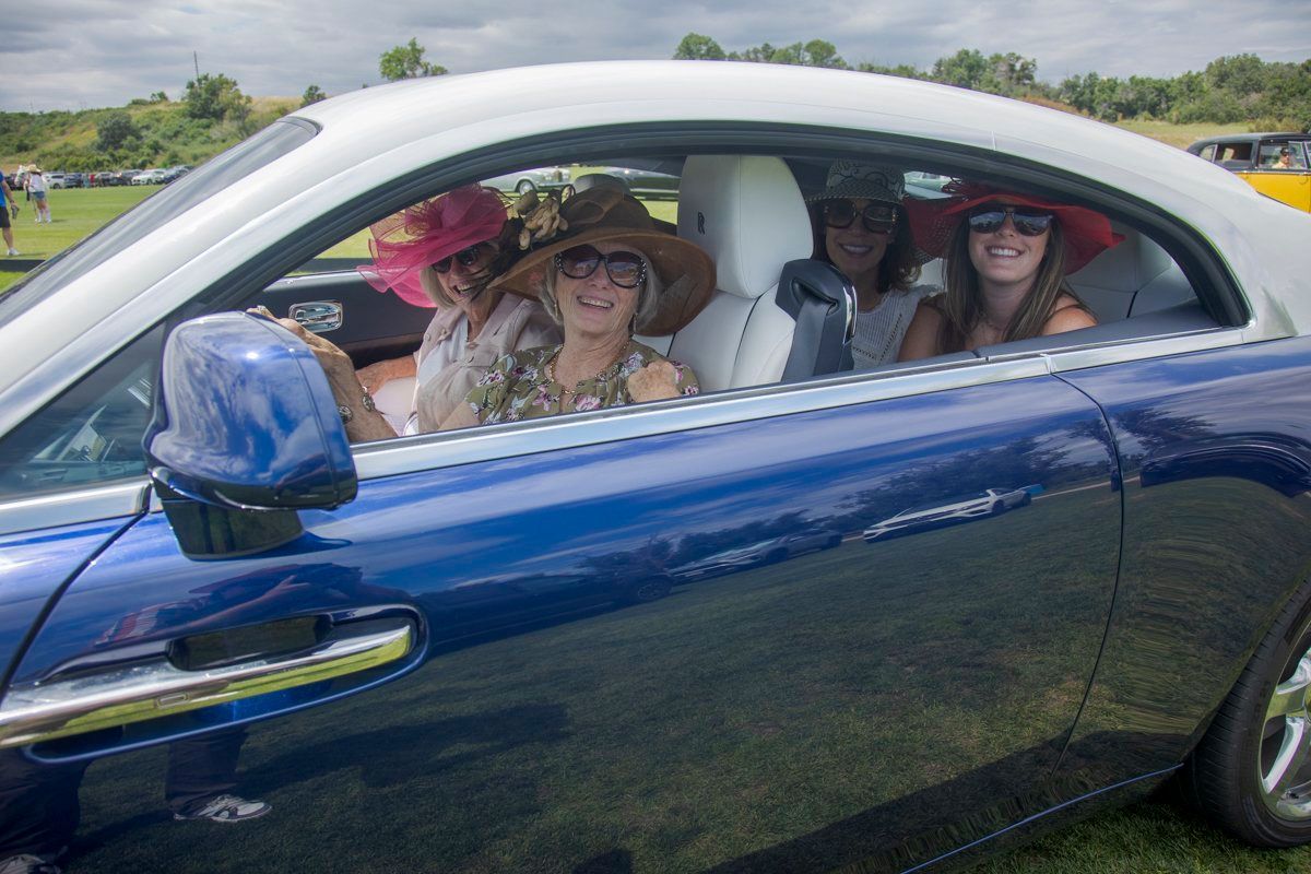 A group of people are sitting in a blue and white car.