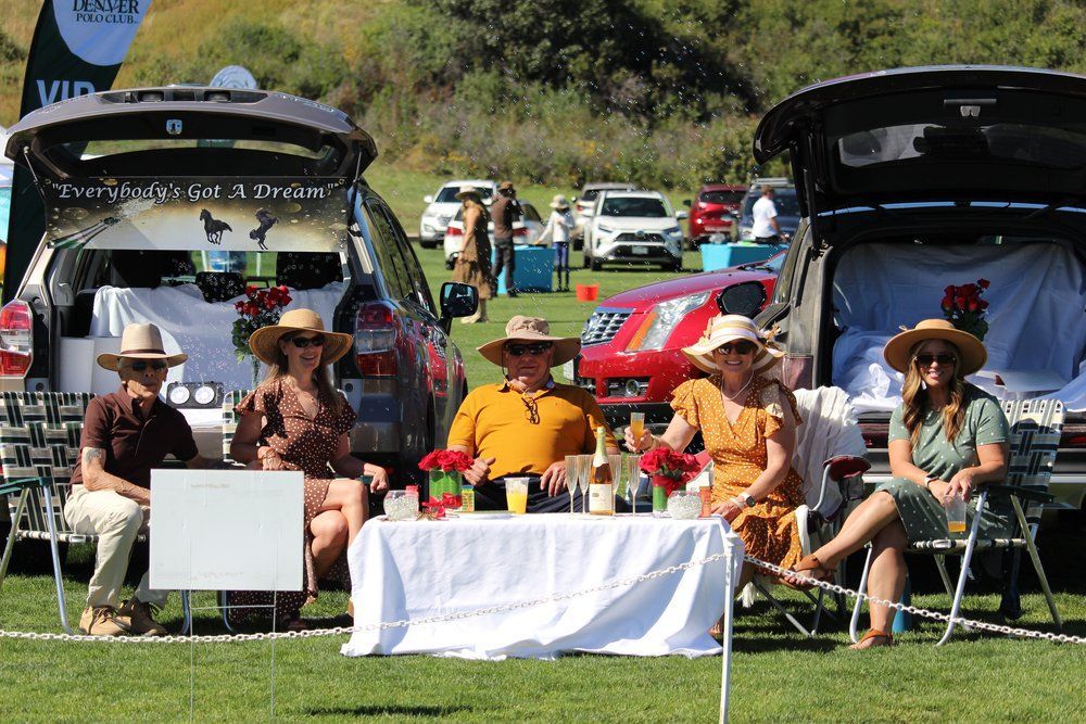 A group of people are sitting at a table in the back of a car.