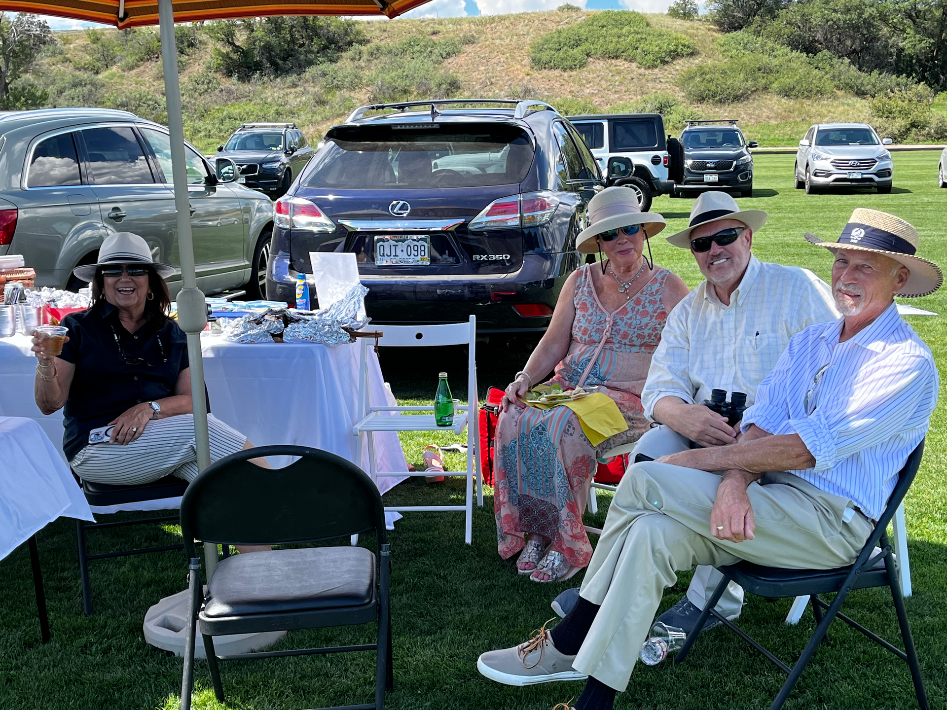 A group of people are sitting in chairs in a field.
