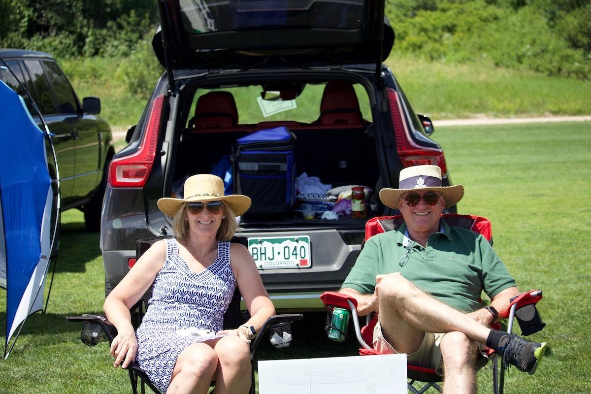 A man and a woman are sitting in the back of a car.
