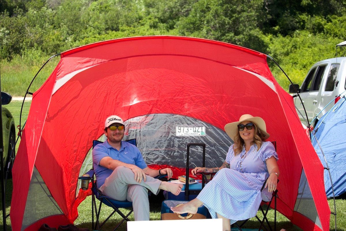 A man and a woman are sitting under a red tent.