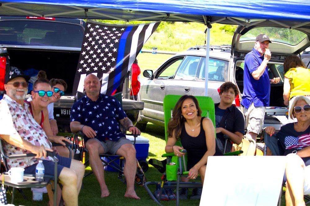 A group of people are sitting under a tent.