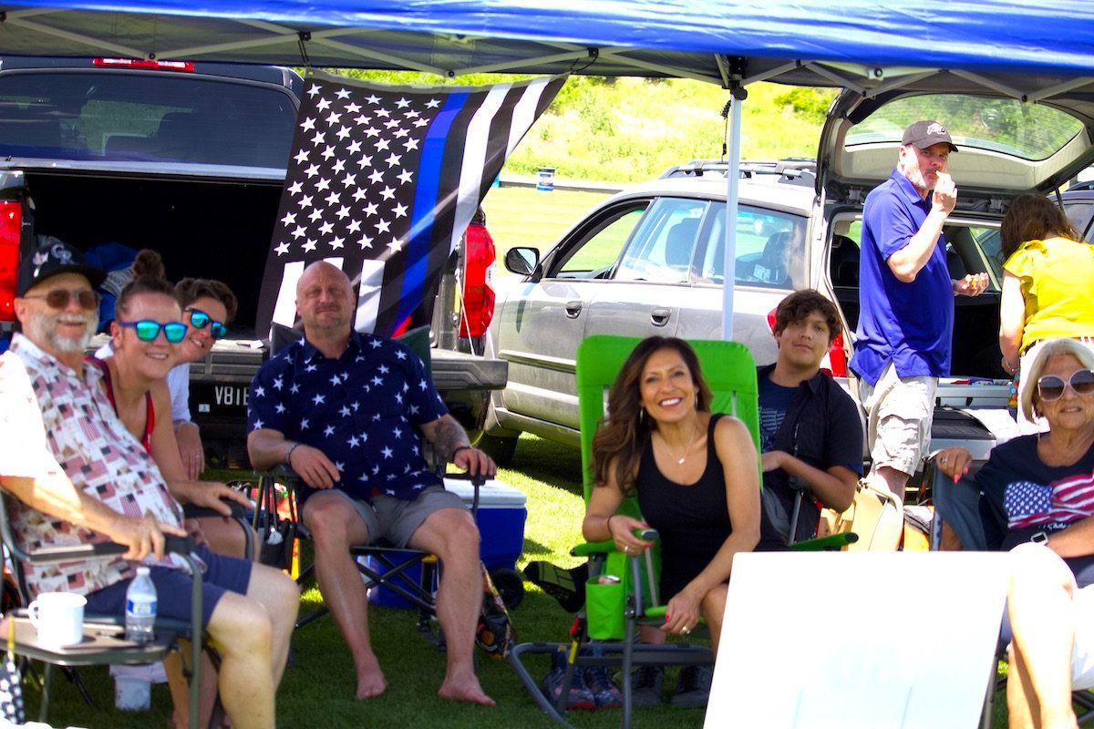 A group of people are sitting under a tent.