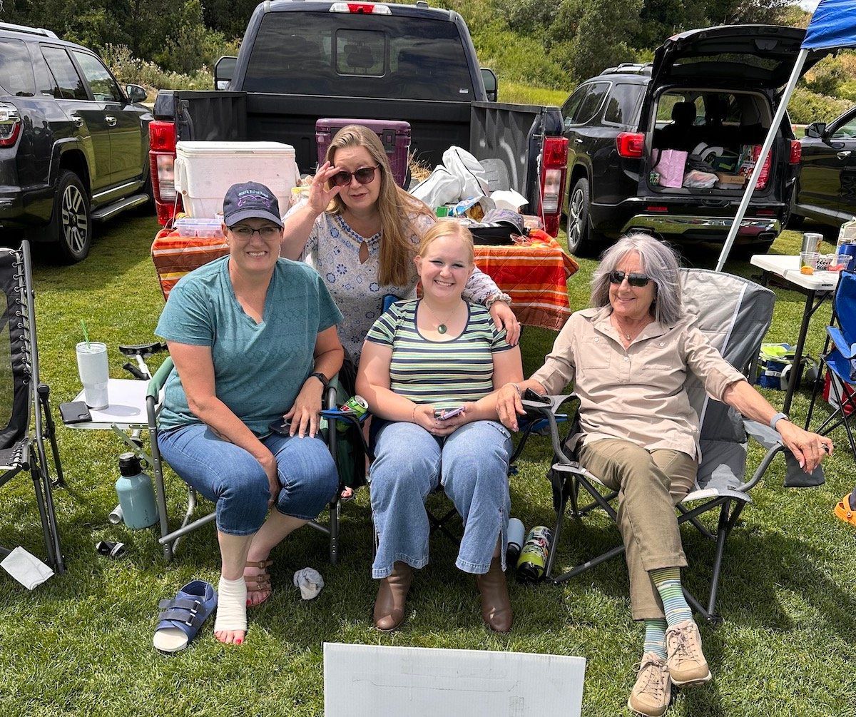 A group of women are sitting in chairs in front of a truck.