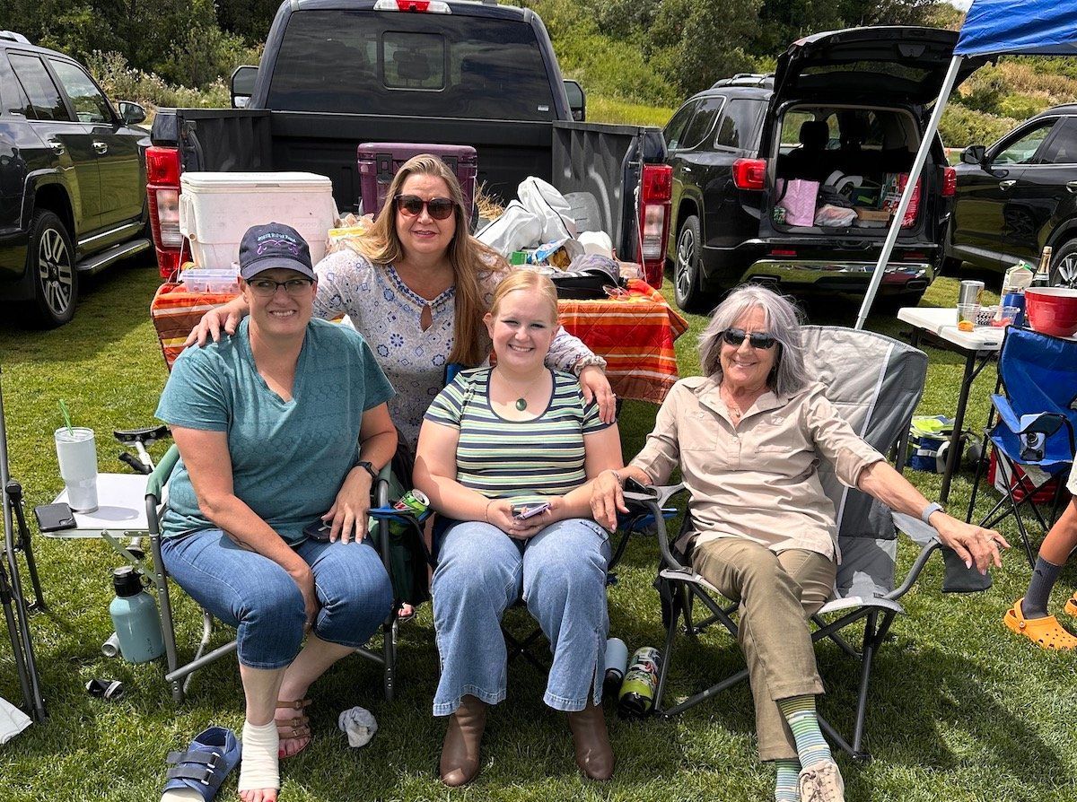 A group of women are sitting in chairs in front of a truck.
