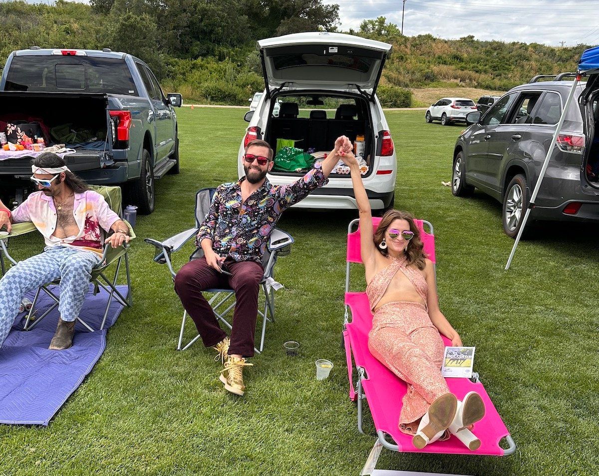 A group of people are sitting in chairs in a field.