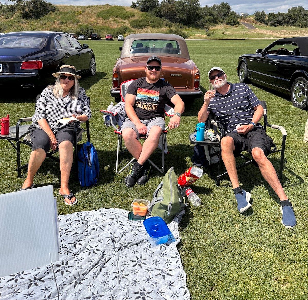 A group of people are sitting in chairs in a field.