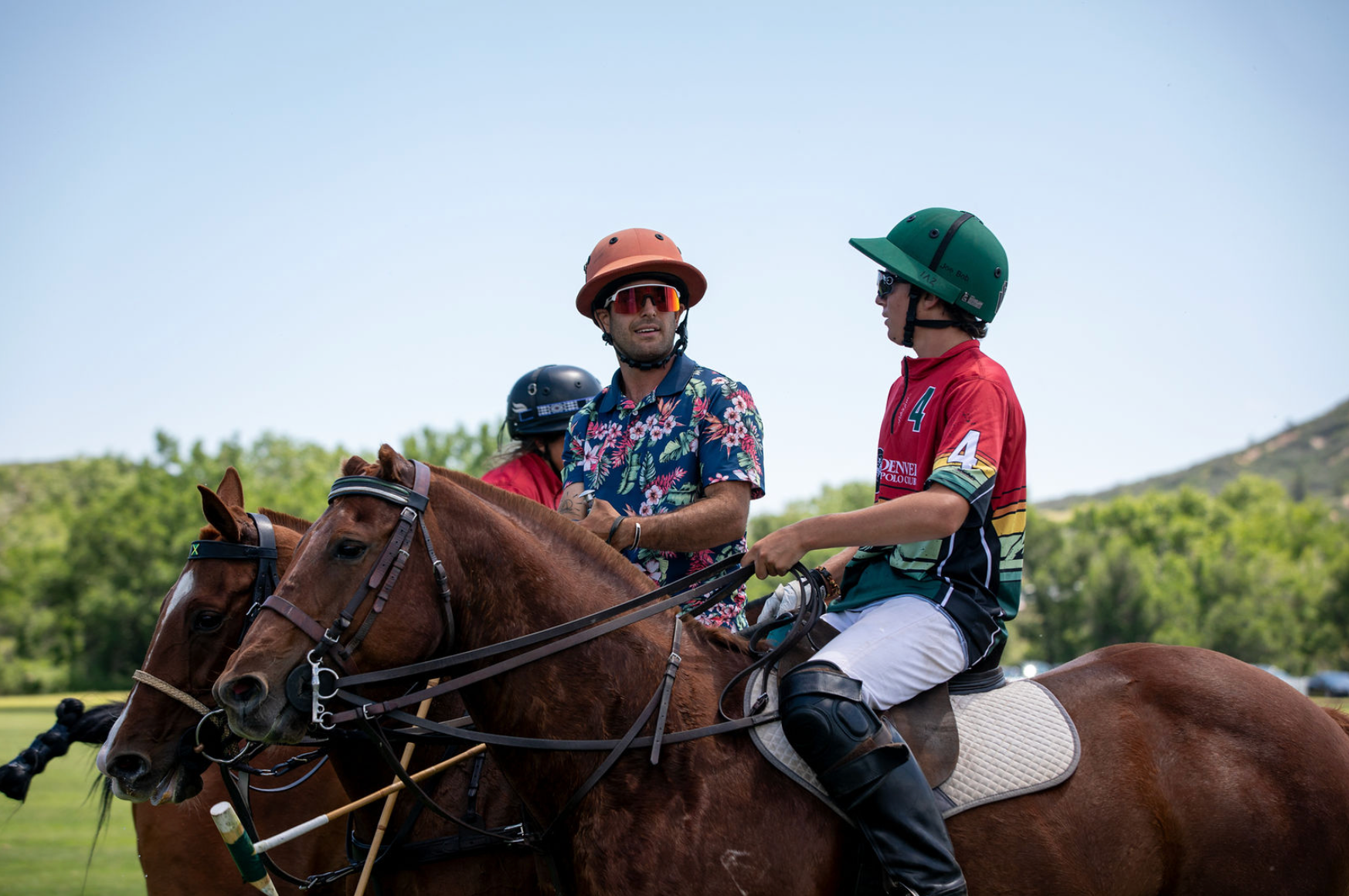 A man and a boy are riding horses in a field.