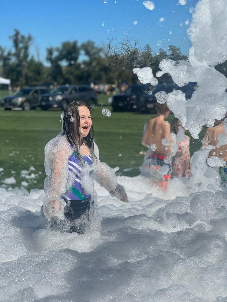 A young girl is playing in a pool of foam.
