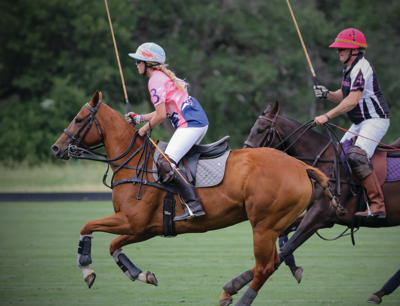 A group of people are riding horses on a field.