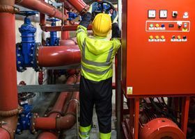 Técnico realizando mantenimiento de extintores en instalación industrial