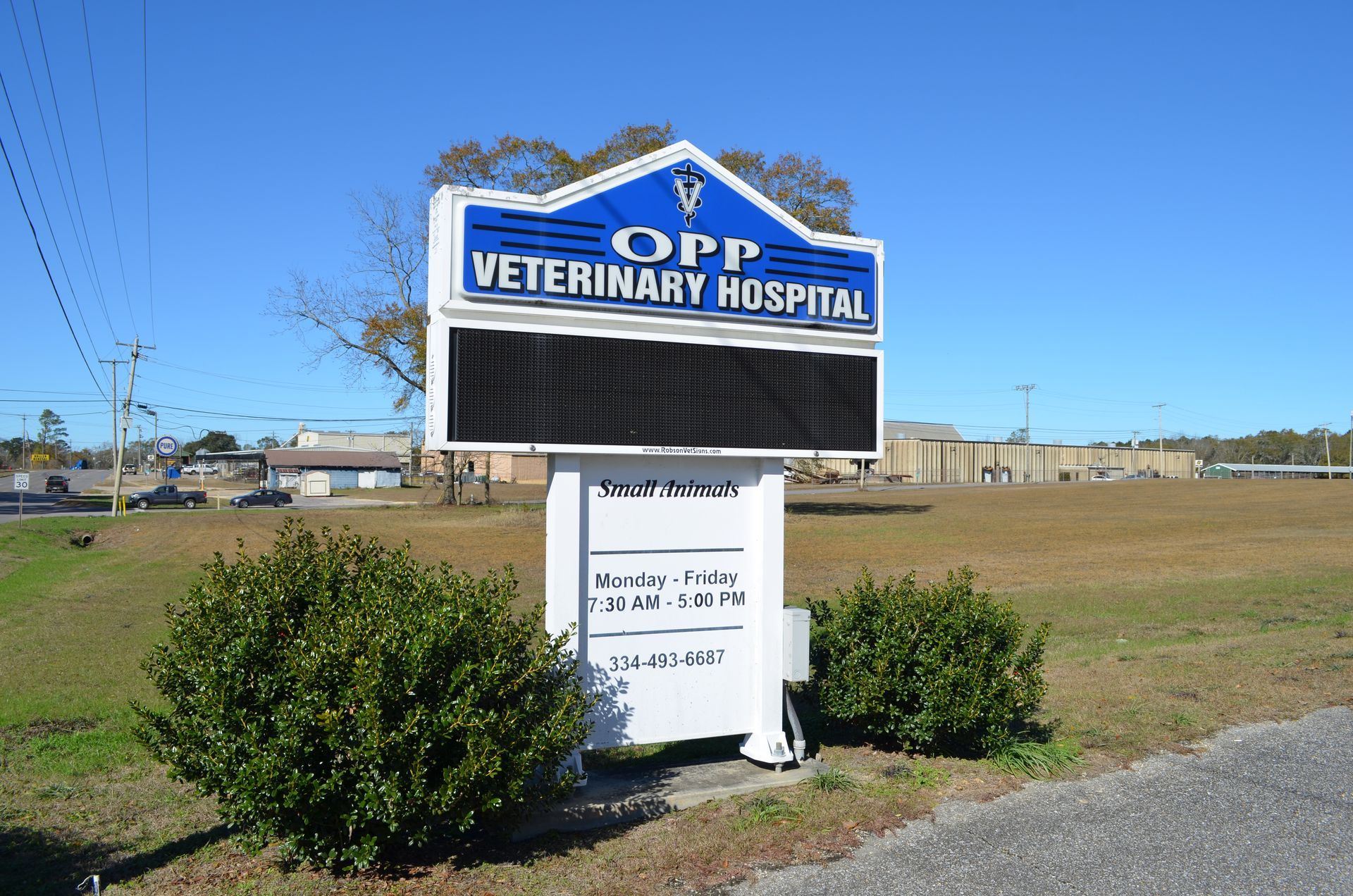 Sign for OPP Veterinary Hospital with an electronic display, hours, and phone number.