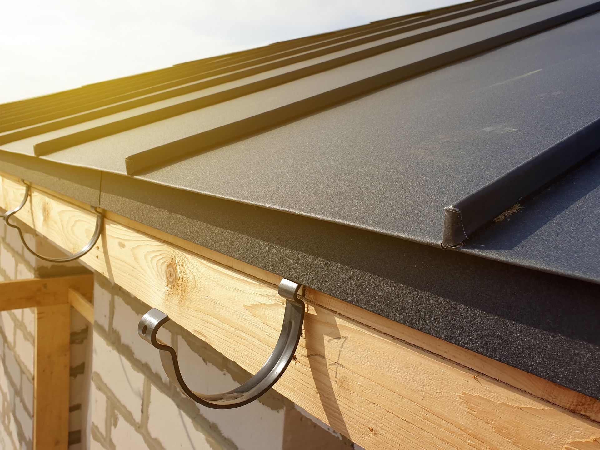 Close up view of folded roof of house under construction with holders for gutters water drainage sys