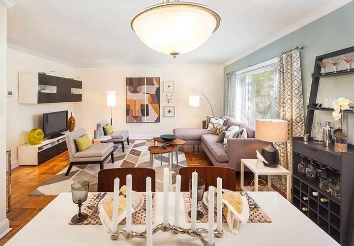 A dining room table with candles on it in a living room.