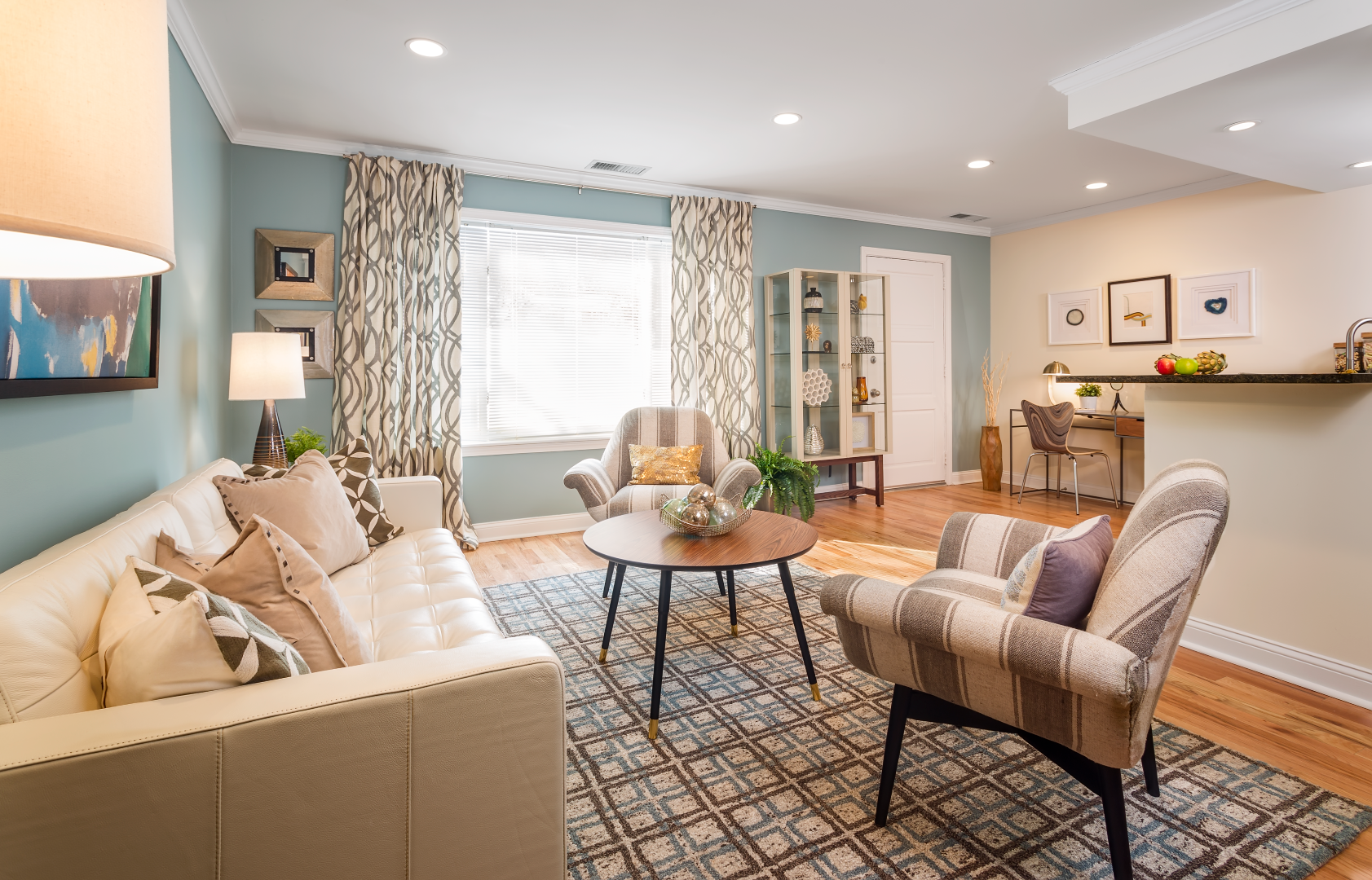 A living room with a couch , chairs , table and rug.