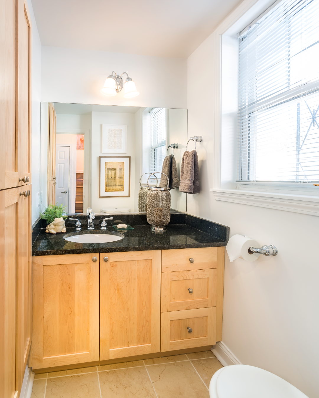 A bathroom with wooden cabinets a sink and a toilet