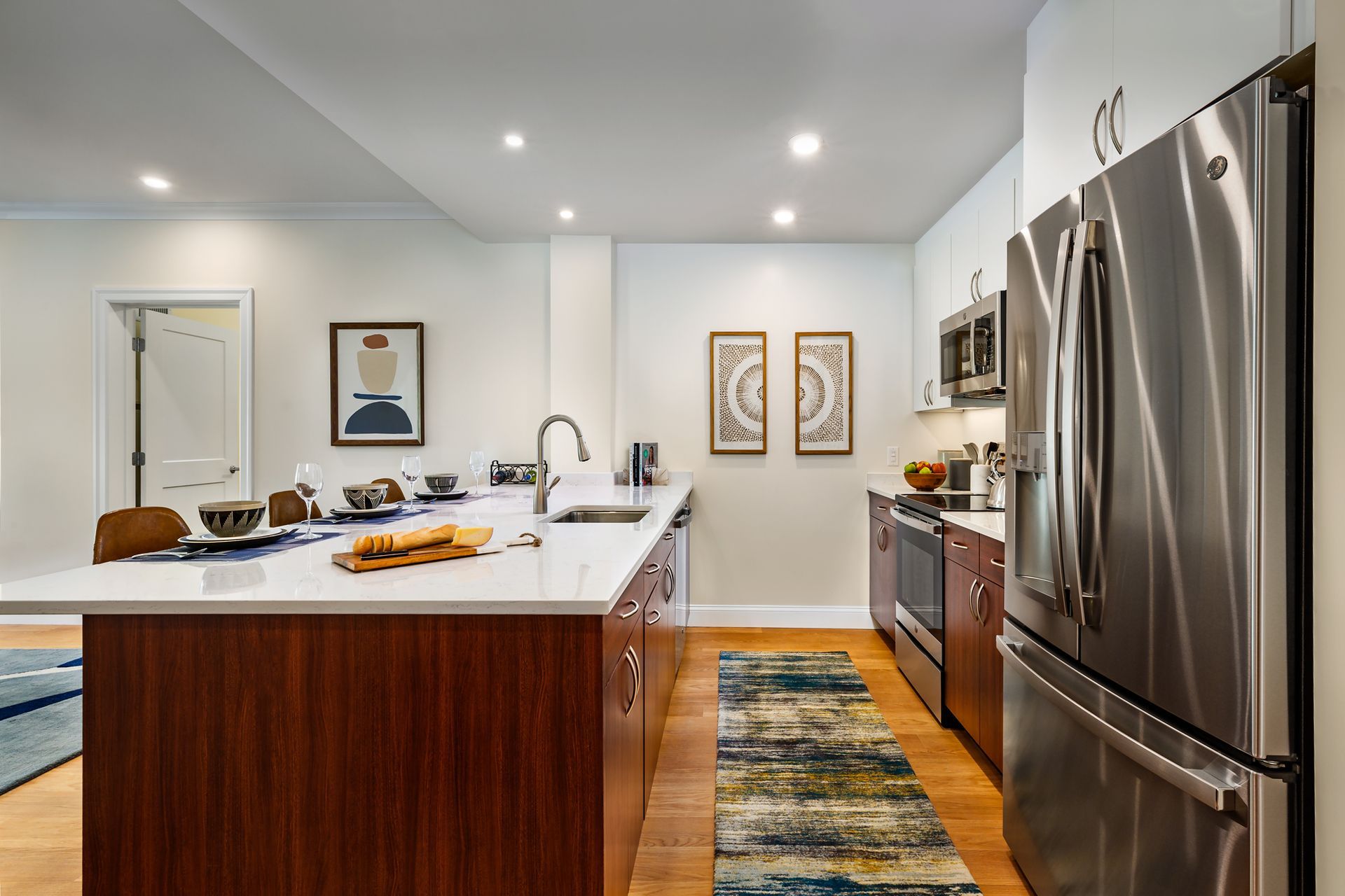 Modern kitchen with island, stainless steel appliances, and wood cabinets.