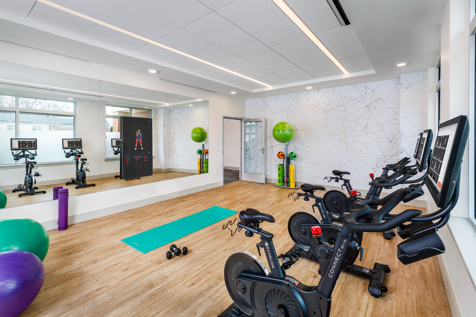 A gym with a lot of exercise equipment and a large mirror.