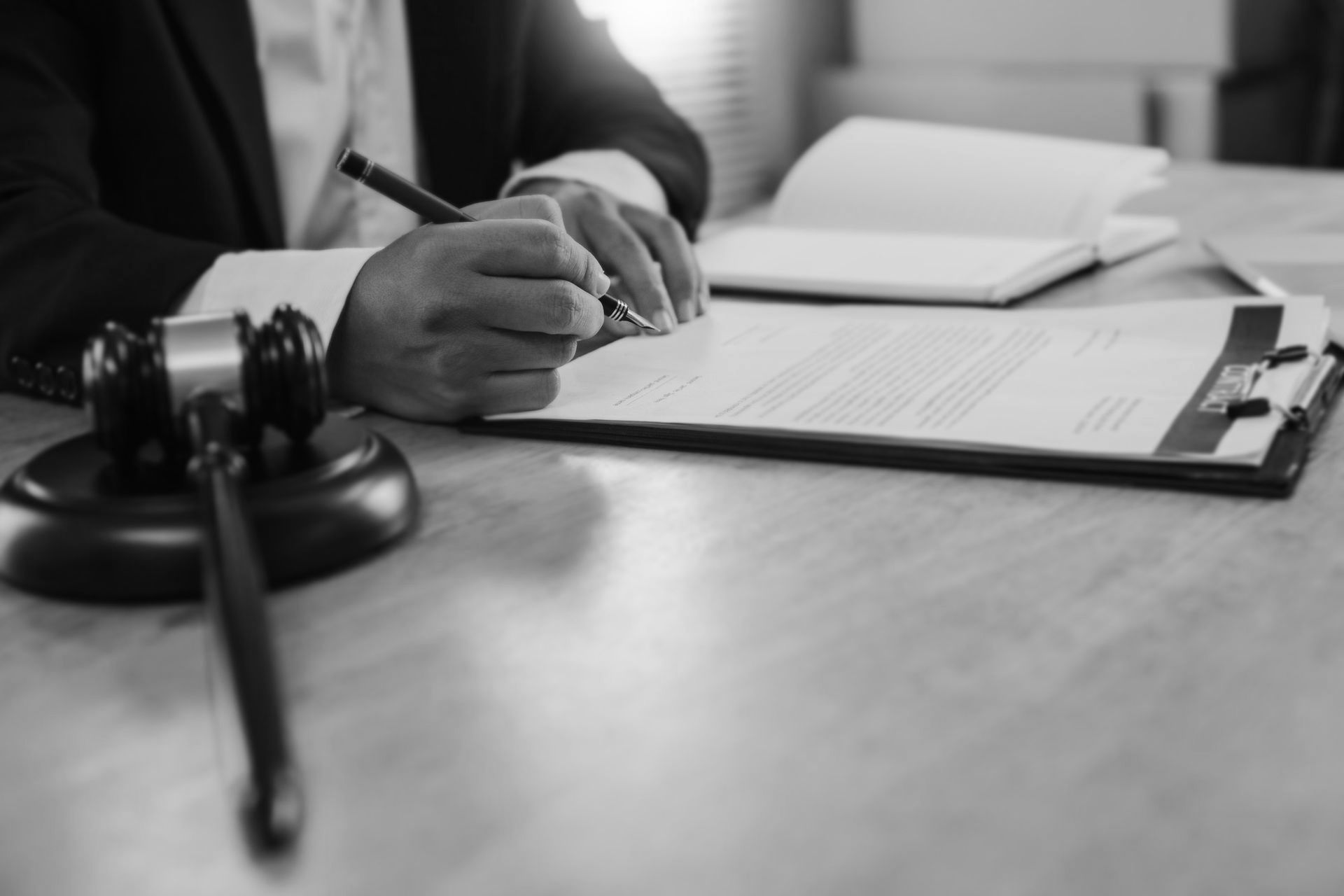 A judge is writing on a clipboard next to a judge's gavel.