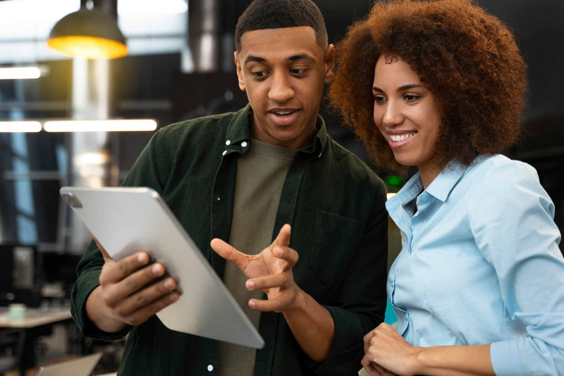 A man and a woman are looking at a tablet together.