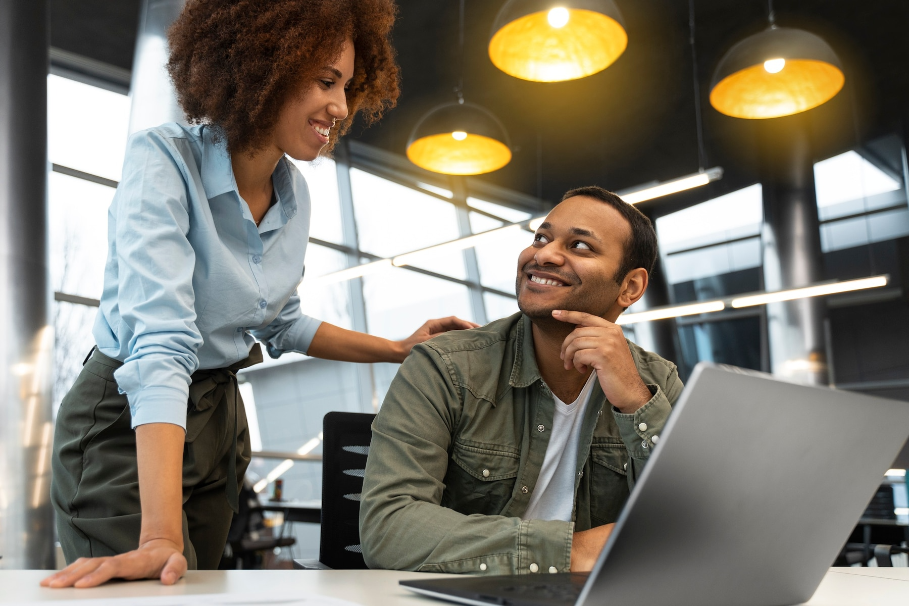 A man and a woman are looking at a laptop computer.