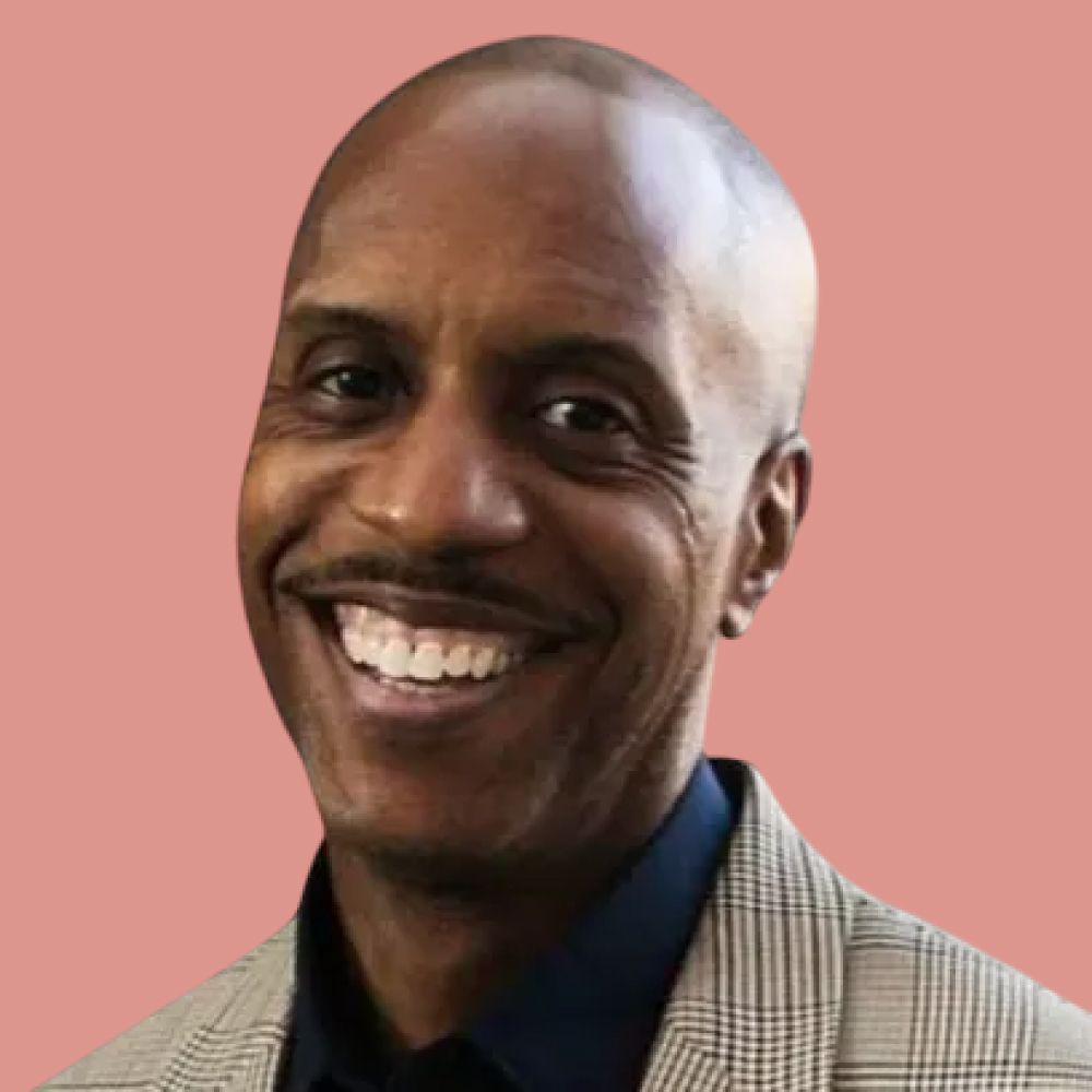 A man in a suit and tie is smiling for the camera.