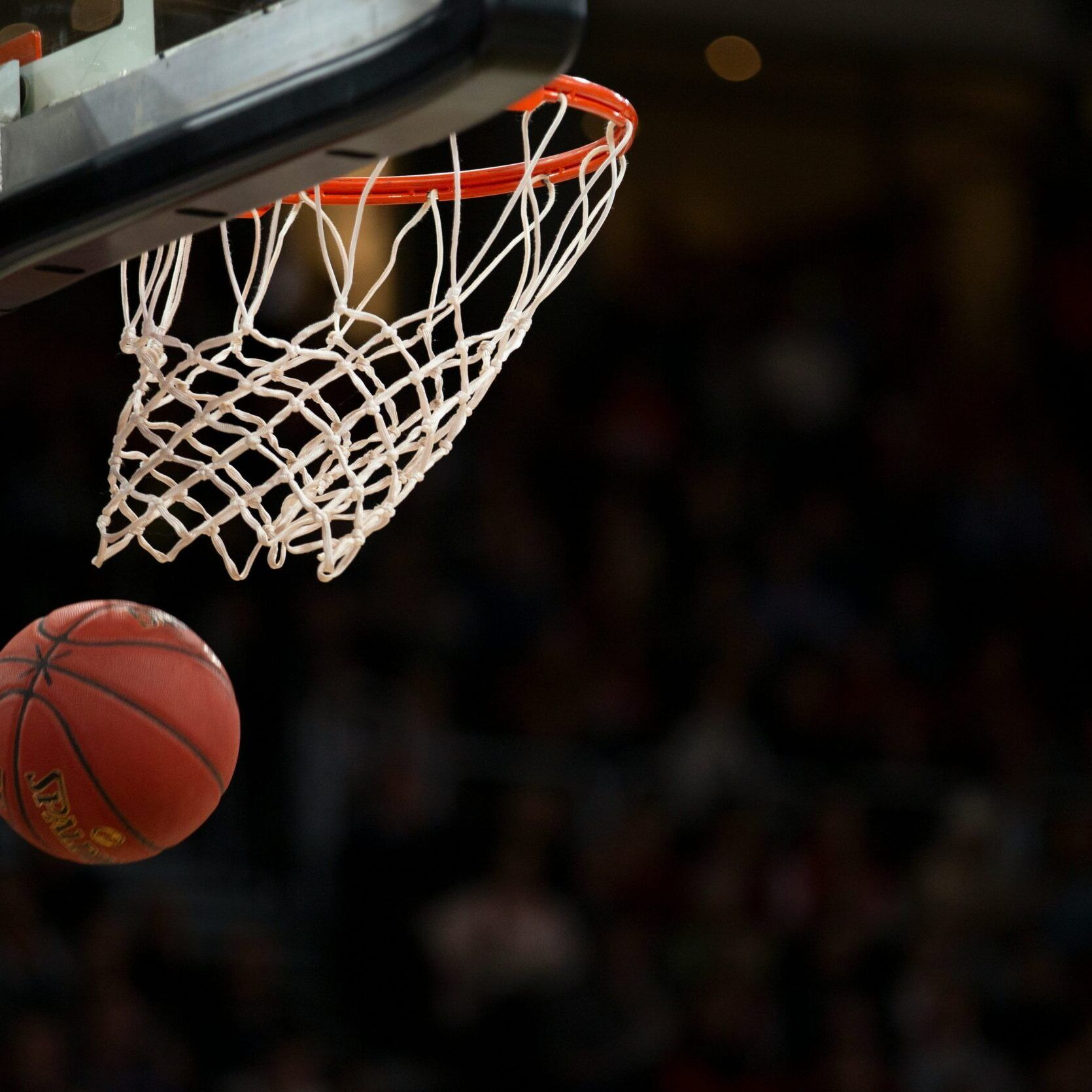 Basketball approaching the hoop and net during a game