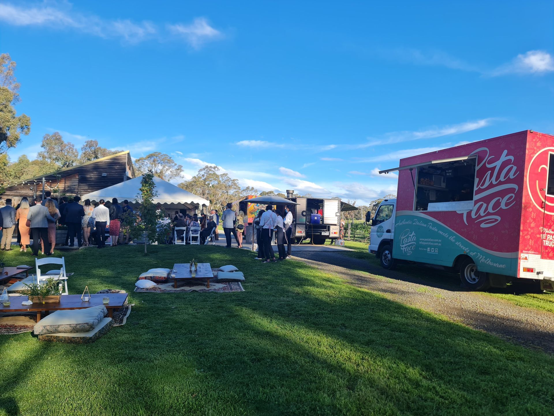Pasta Face food truck catering an outdoor country wedding with guests gathered near the reception marquee