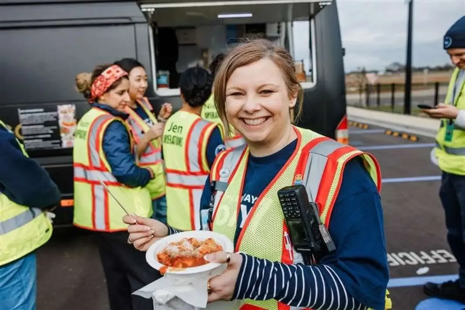 Warehouse team member enjoying a Pasta Face pasta meal beside the onsite mobile kitchen in Melbourne