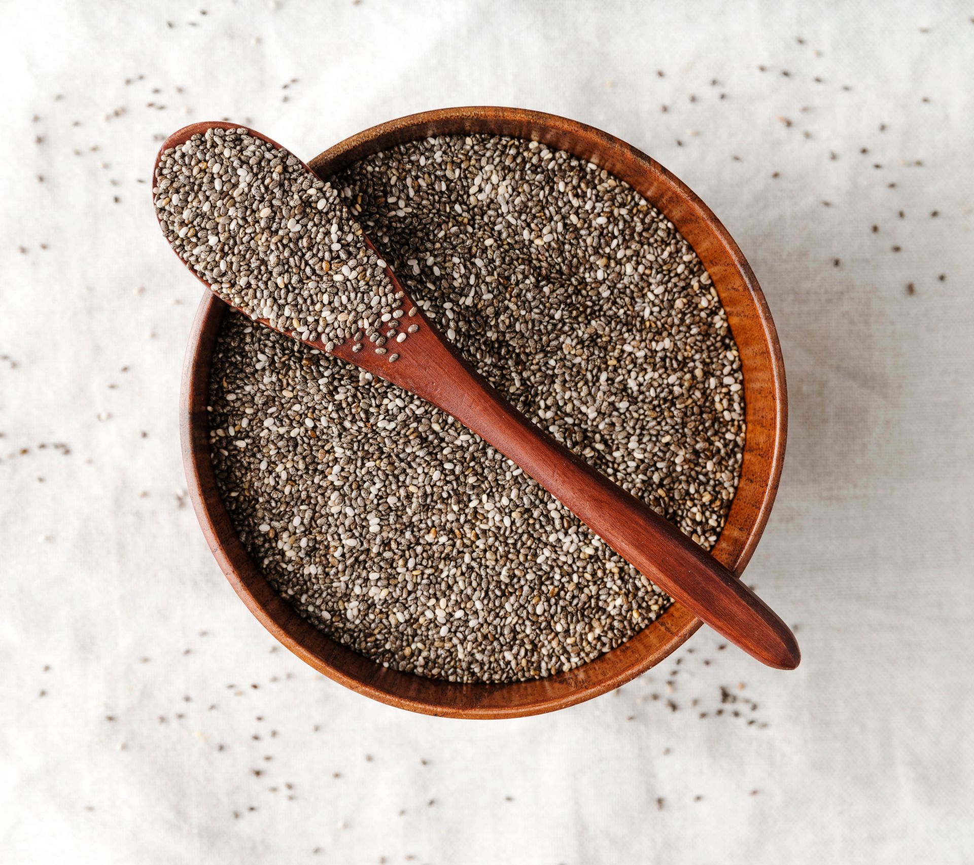 Un bol de graines de chia avec une cuillère en bois dedans