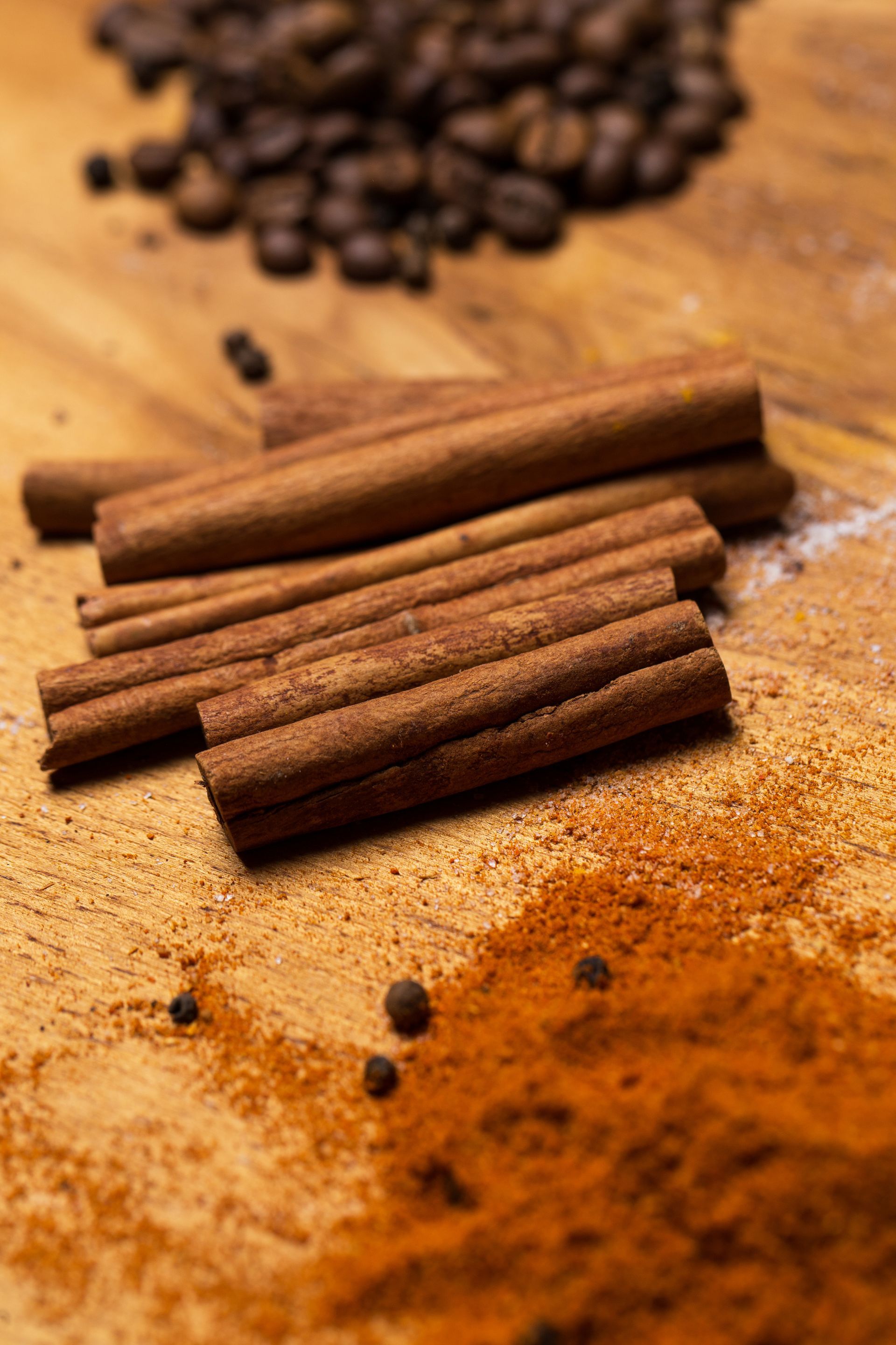 Bâtons de cannelle et grains de café sur une table en bois.