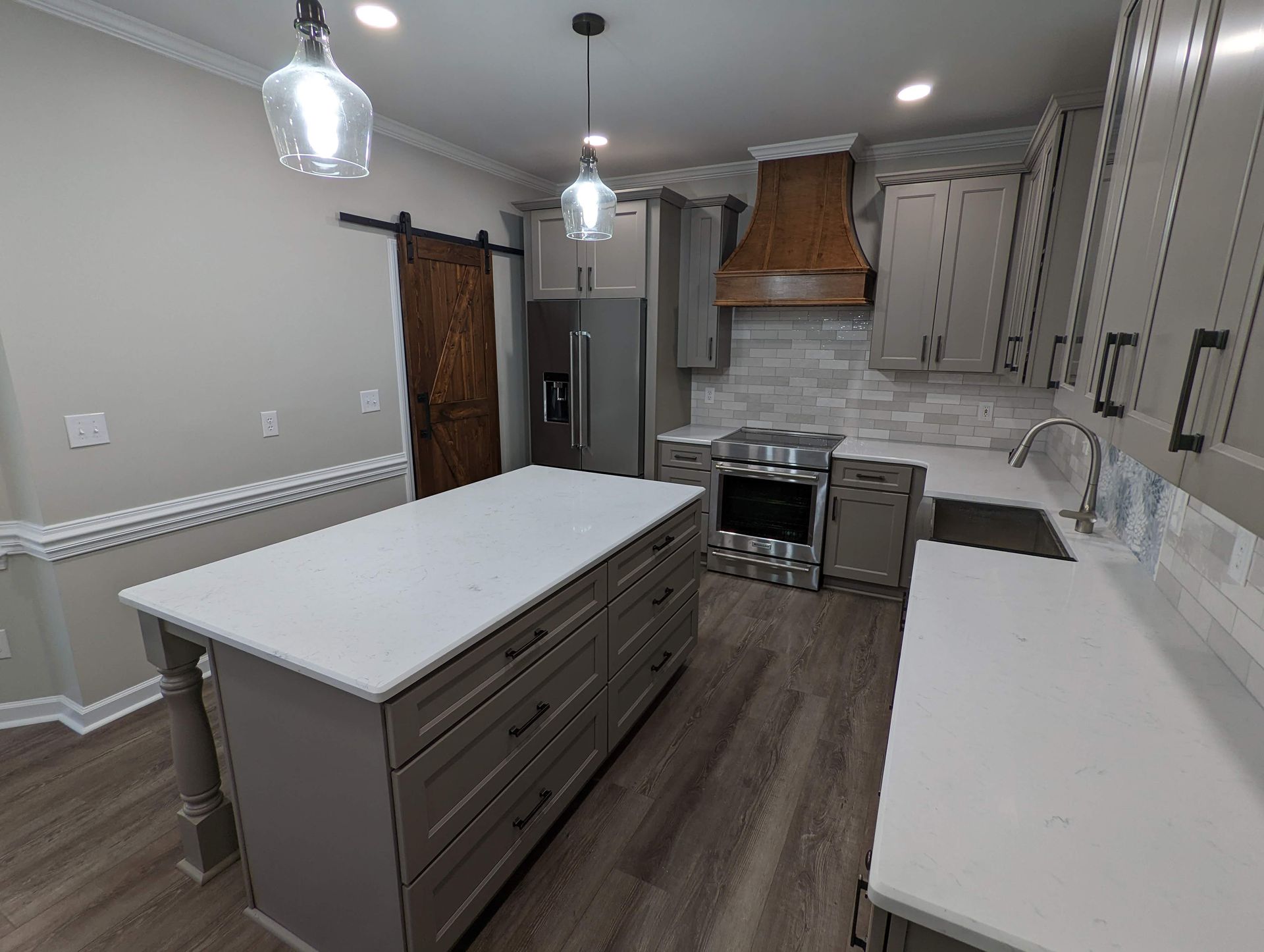 Kitchen with gray cabinets, white counters, and a large island.