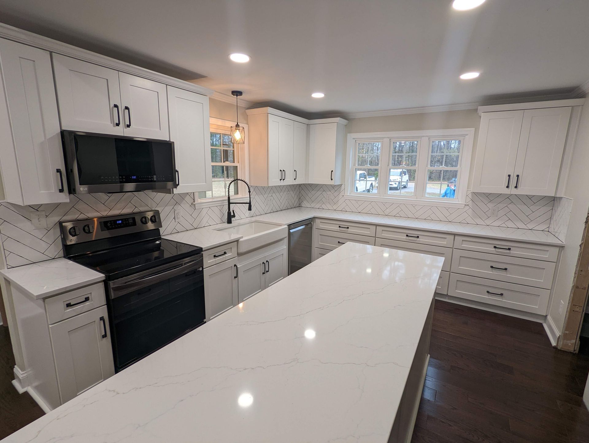 Bright kitchen with white cabinets, large island, and stainless steel appliances.