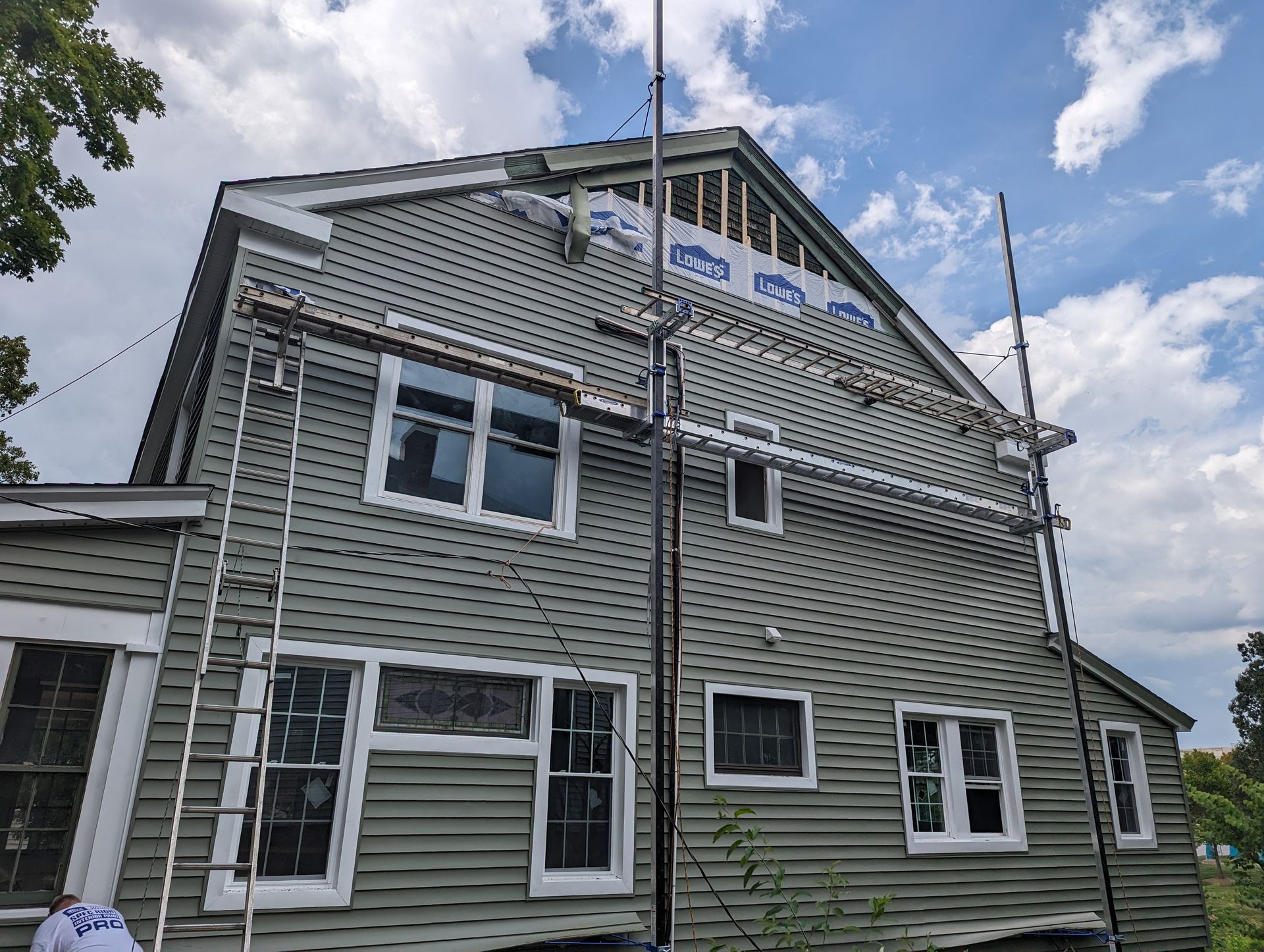 Home exterior under construction with siding and scaffolding.