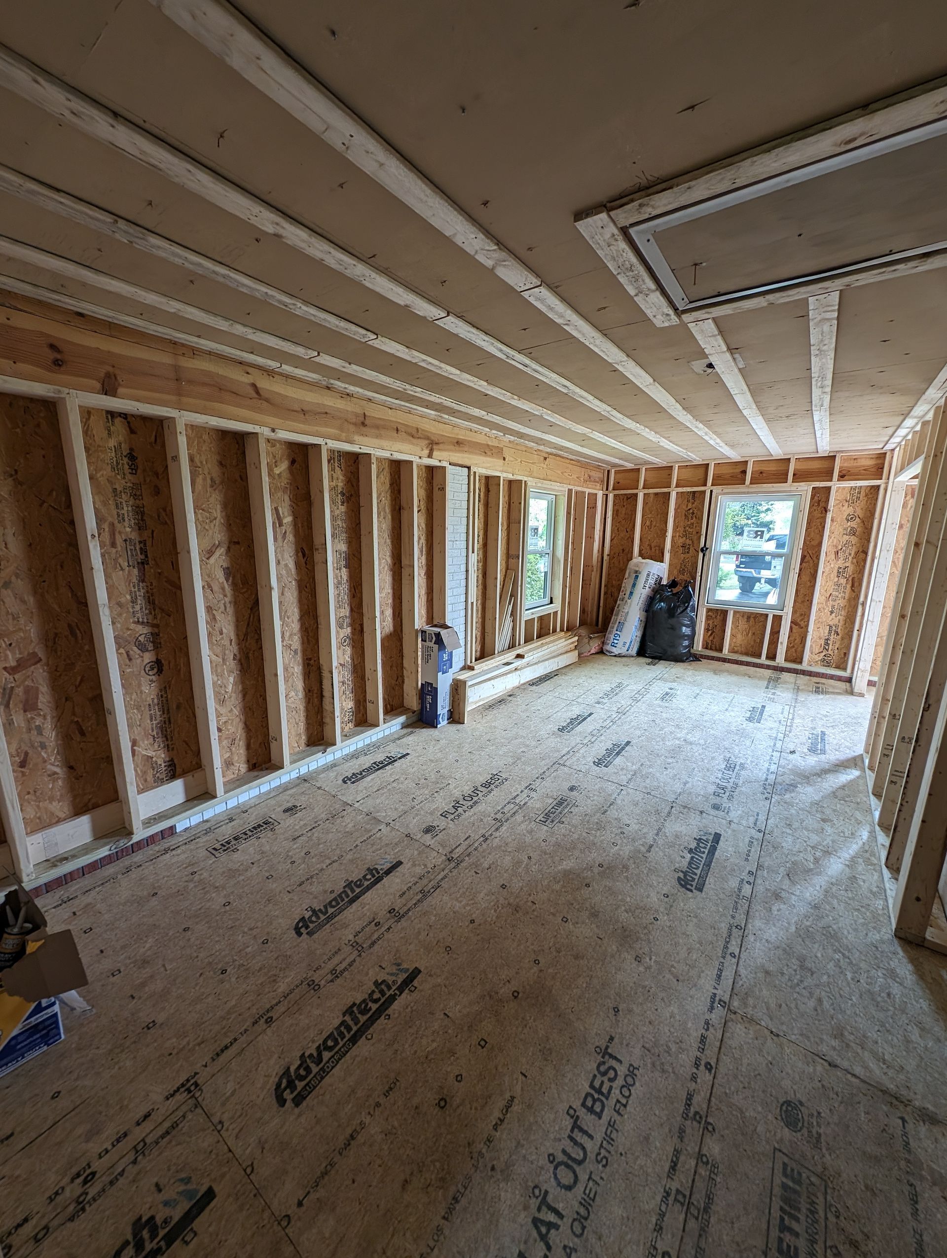 Room under construction with exposed studs and ceiling work.